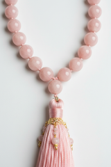 Close-up of Le Amara Mala blush gemstone beads and tassel craftsmanship