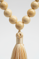 Macro close-up of Le Sattva Mala ivory bead texture and handcrafted cord craftsmanship