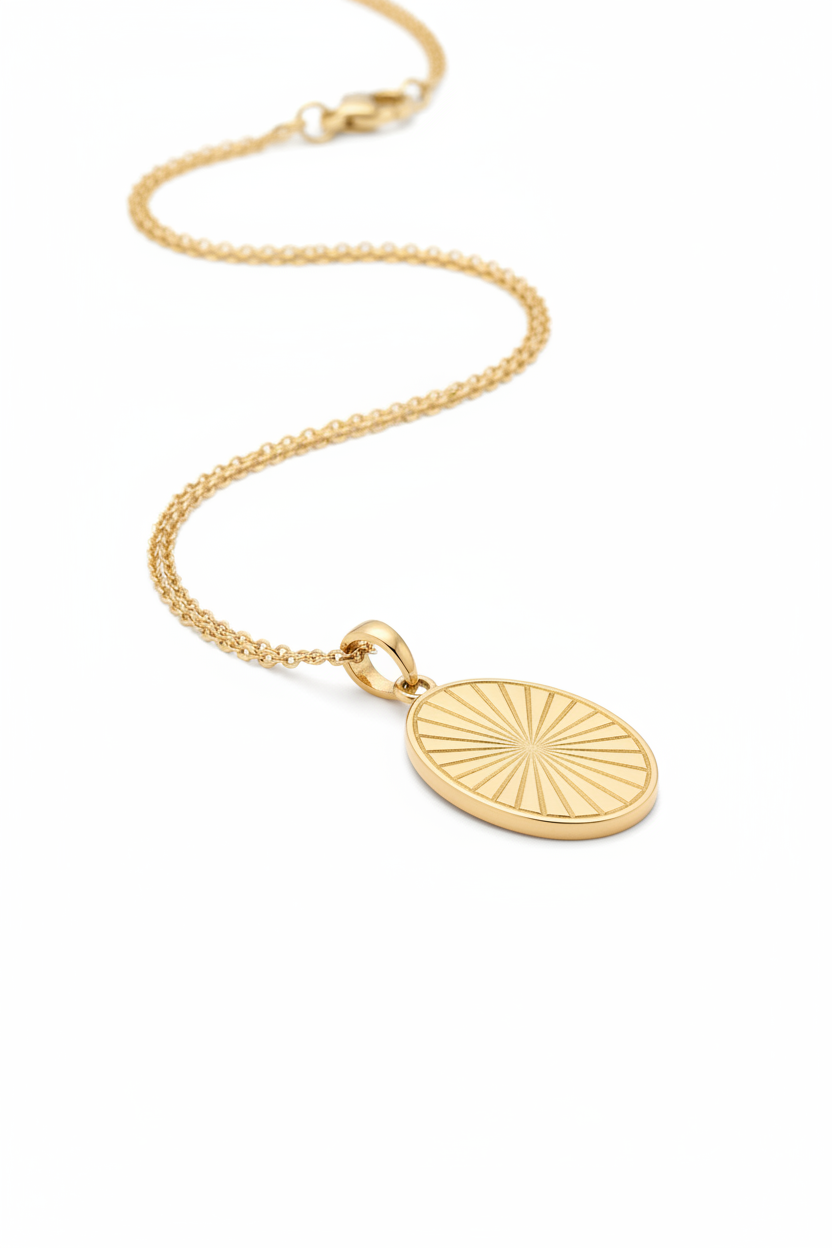 Luxury gold oval pendant necklace with geometric sunburst engraving, side angle view
