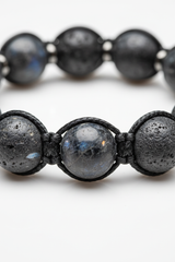 Macro close-up of Aura Bead Bracelet dark gemstone bead surface and handcrafted cord craftsmanship