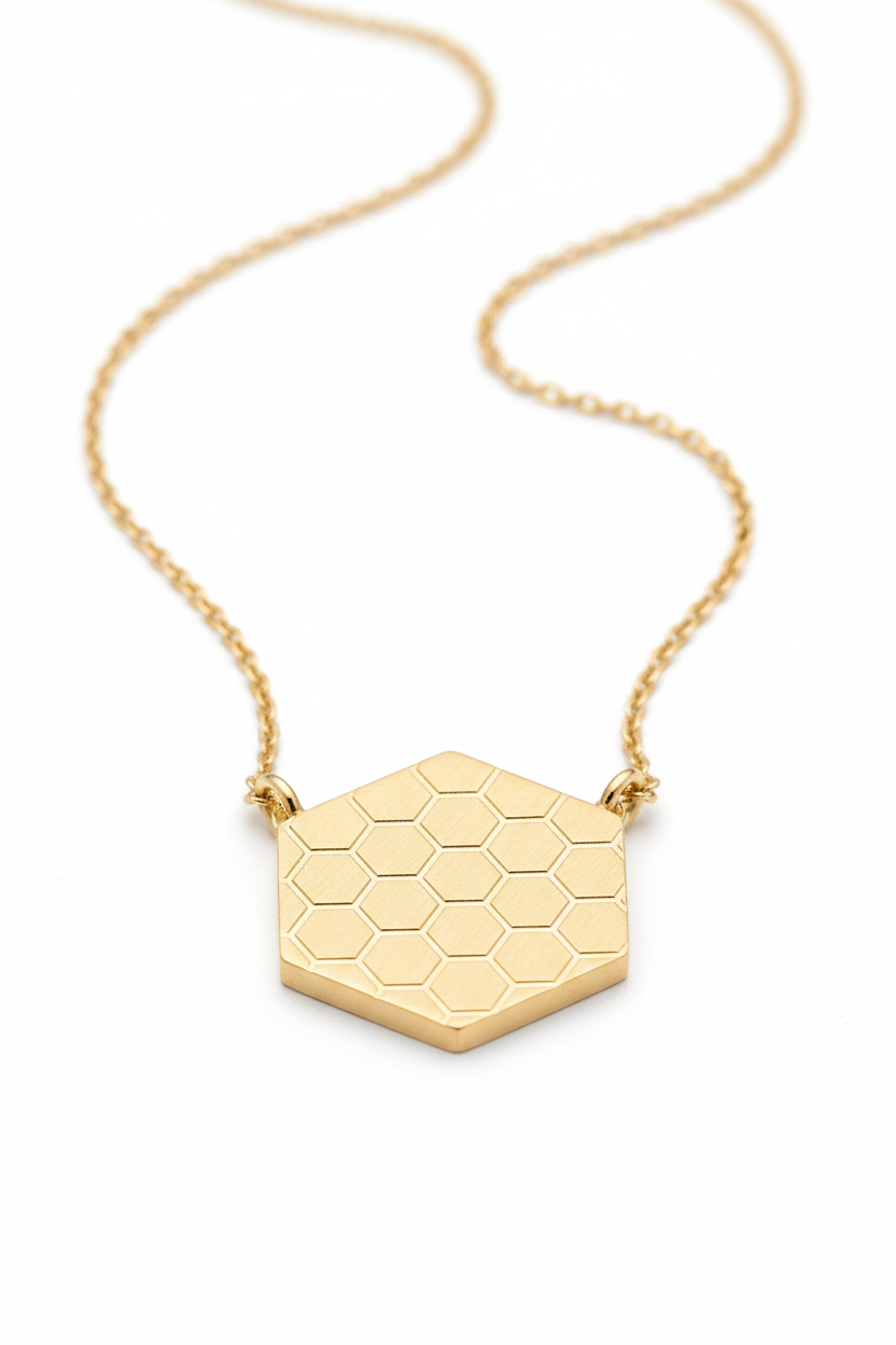 Jewelry macro close-up of Eternal Glow Necklace showing hexagonal gold pendant honeycomb texture and chain detail