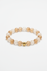 Luxury spiritual bead bracelet with champagne moonstone and cream selenite beads and gold double heart charm, front view
