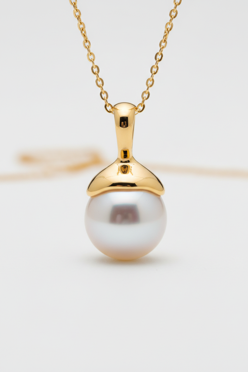 Close-up of Le Pearl lustrous pearl pendant with gold setting