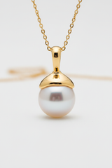 Close-up of Le Pearl lustrous pearl pendant with gold setting