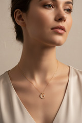 Elegant female model wearing Le Mirage celestial gold pendant necklace