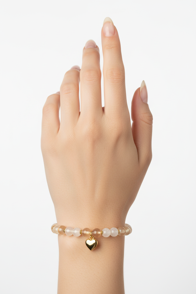 Elegant female hand wearing Heart Soul Bracelet with champagne moonstone beads and gold double heart charm