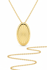 Macro jewelry image of Sacred Light Necklace showing oval gold pendant sunburst engraving and chain detail