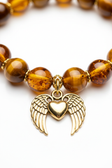 Macro jewelry image of Golden Love Bracelet showing tiger's eye chatoyancy and gold winged heart charm detail
