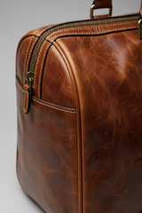 Le Compact Weekender in Brown, portrait leather and zipper macro close-up