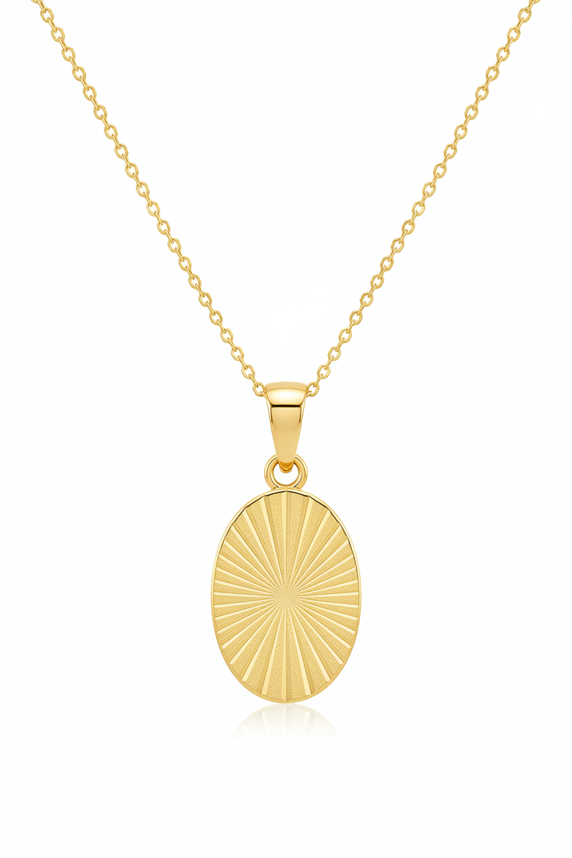 Luxury gold oval pendant necklace with geometric sunburst engraving, front view on white background