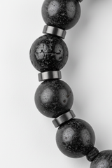 Close-up of premium dark gemstone beads on Aura Bead Bracelet with soft luxury reflections