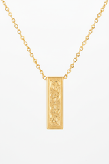 Jewelry macro close-up of Inner Power Necklace showing gold pendant engraving and chain detail