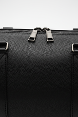 Le Compact Weekender in Black, portrait leather and zipper macro close-up
