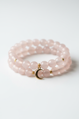 Luxury feminine spiritual bracelet with rose quartz beads and gold crescent moon charm, side angle