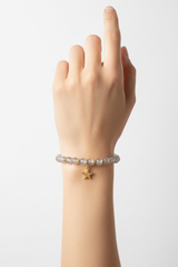 Elegant female hand wearing Serenity Crystal Bracelet with moonstone beads and gold star charm