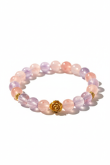 Luxury feminine gemstone bracelet with blush pink strawberry quartz and lavender amethyst beads and gold rose charm, centered on white background