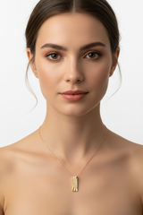 Elegant female model wearing Inner Power Necklace with gold rectangular pendant and fine chain