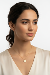 Elegant female model wearing Golden Aura Necklace with circular gold disc pendant and fine chain