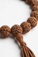 Macro close-up of Rudra Mala Necklace natural rudraksha bead surface and handcrafted cord craftsmanship