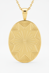 Close-up pendant detail of oval gold pendant with geometric sunburst engraving on Sacred Light Necklace