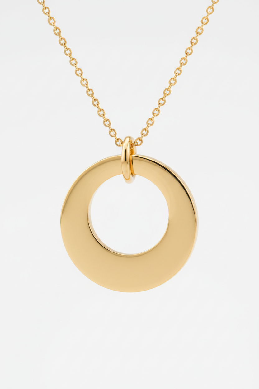 Macro close-up of Le Harmonie smooth circular gold pendant