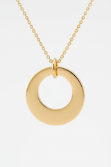 Macro close-up of Le Harmonie smooth circular gold pendant