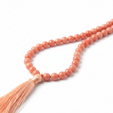 Coral pink mala necklace angled side view