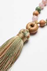 Close-up of Le Zen Mala elegant silk tassel in sage green and earth tones